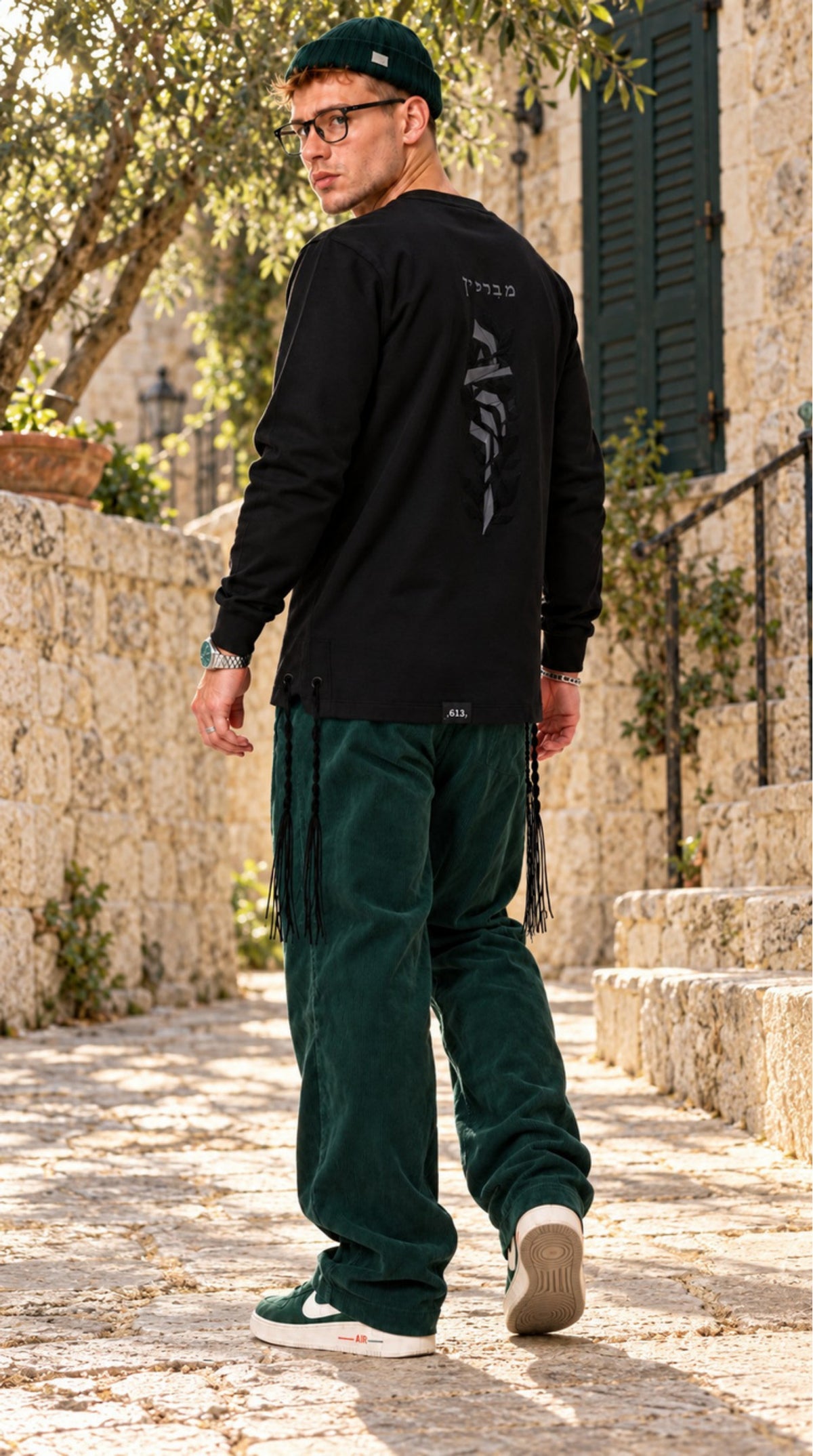 Blessing Circle של 613, חולצת ציצית שחורה עם שרוול ארוך, צילום חוץ במדרגות אבן